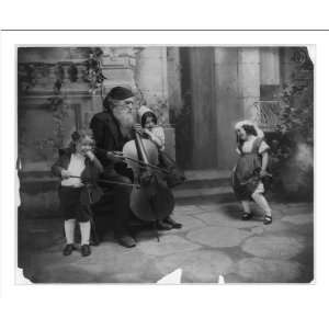   Bearded man and 2 children with cello & violin and small girl dancing